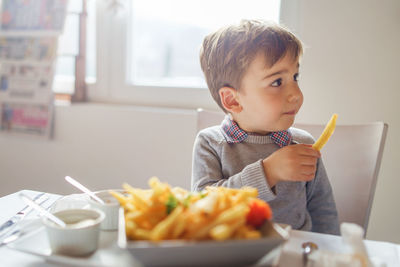 Boy sitting on table at home