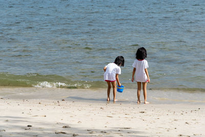 Rear view of women standing on beach