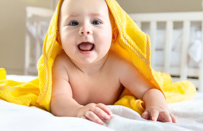 Portrait of baby girl with towel on head at home