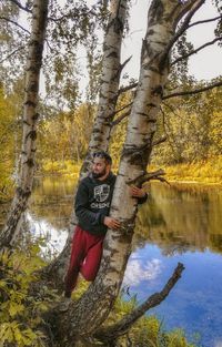 Reflection of man in lake against trees in forest