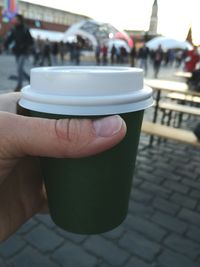 Close-up of hand holding coffee cup