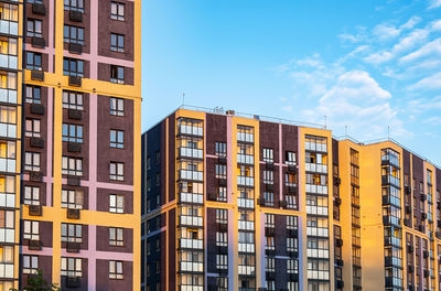 High-rise residential buildings with colorful facades during sunset.
