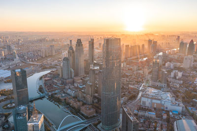 Morning sunshine casting over modern city, aerial shot of cityscape