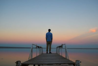 Rear view of man standing on pier