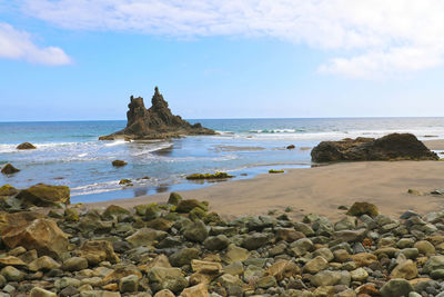 Rocks on beach against sky