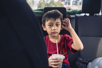 Portrait of young woman sitting in car