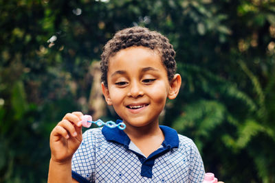 Smiling boy playing with bubble wand