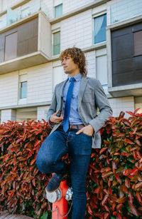 Fashionable businessman standing against building