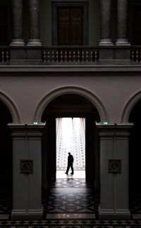 Rear view of silhouette man standing against building