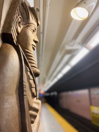 Close-up of statue by train at railroad station