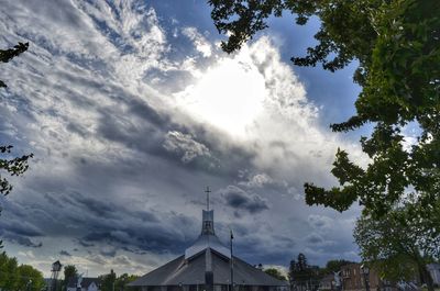 Low angle view of trees and building against sky