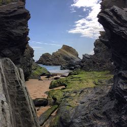 Rock formation at beach against sky