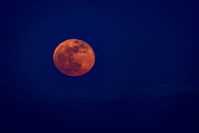 Low angle view of moon against clear blue sky
