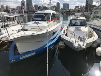 Boats moored at harbor by buildings in city