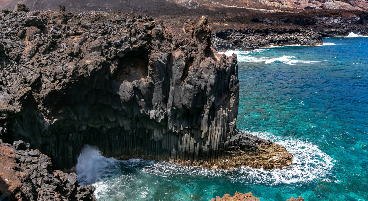 PANORAMIC VIEW OF ROCK FORMATION ON SEA