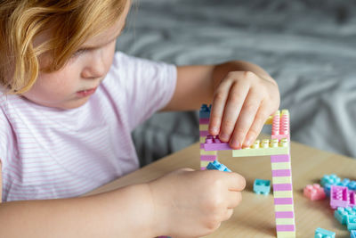 Cute girl playing with block shapes on table