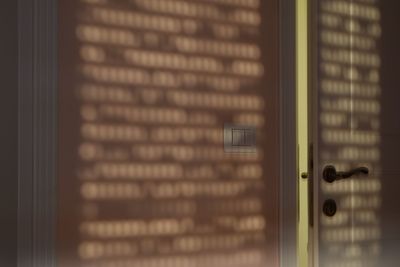 Close-up of grid shadow on wall and door