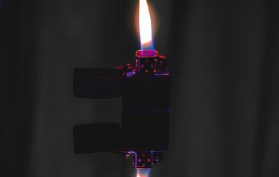 Close-up of lit candles in darkroom