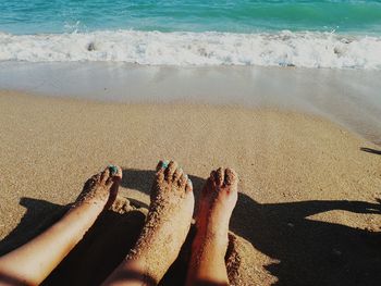 Low section of people sitting at beach