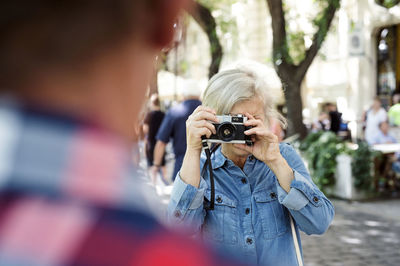 Senior woman taking picture of her partner with camera