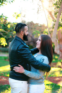 Couple embracing while standing at park