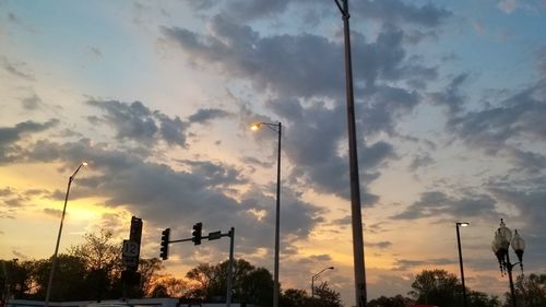 Low angle view of street lights against sky during sunset