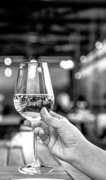 Close-up of hand holding wine glass on table