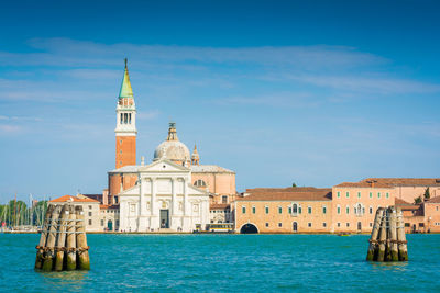 View of buildings by sea against sky