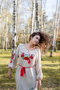 Beautiful woman in national ukrainian national traditional costume clothes dancing in forest