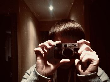 Close-up of man photographing with camera at home