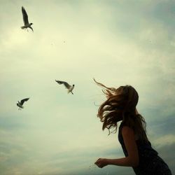 Seagull flying against cloudy sky