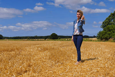 Full length of young woman standing on field