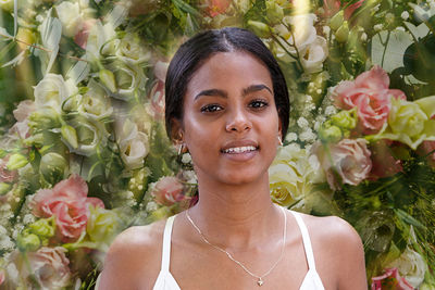 Portrait of smiling woman by pink flowers outdoors