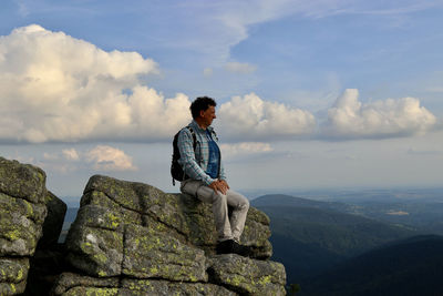 Full length of man looking at mountains against sky