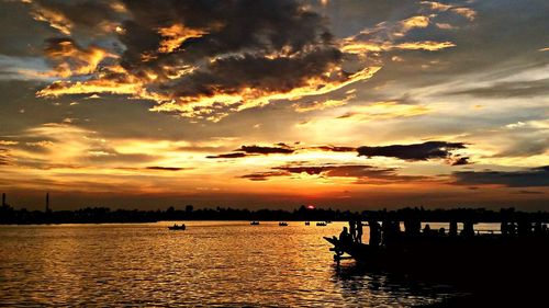 Scenic view of sea against cloudy sky at sunset