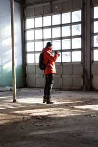Full length of man photographing while standing in abandoned room