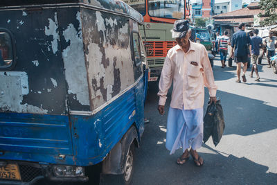 Rear view of man walking on street in city