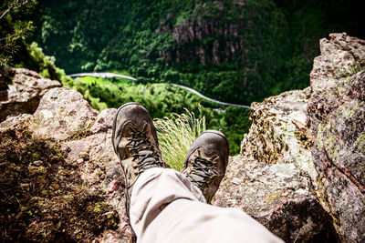 Low section of person relaxing on rock