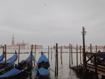 Boats moored in canal against sky
