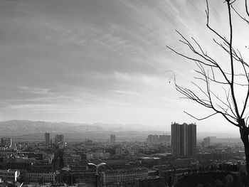 View of cityscape against cloudy sky