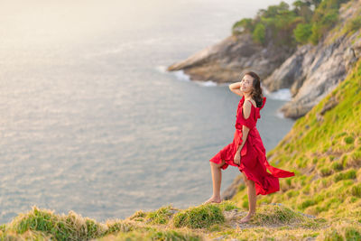 Woman with red umbrella on land