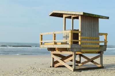 Lifeguard hut on beach against sky