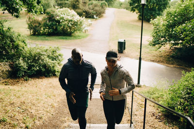 Men standing on sidewalk against trees