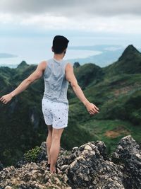 Full length rear view of man standing on rock