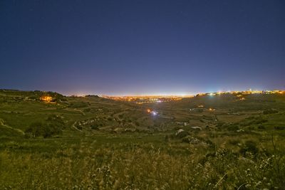 Scenic view of field against clear sky at night