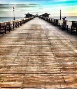 View of wooden pier at beach against sky