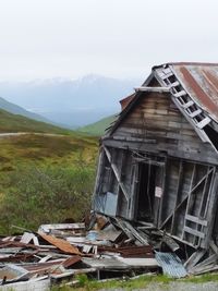 Abandoned house on field against sky