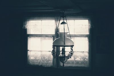 Close-up of electric lamp hanging on window