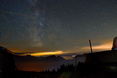 Scenic view of silhouette mountains against sky at night