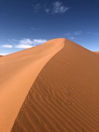 Sand dunes in desert against sky